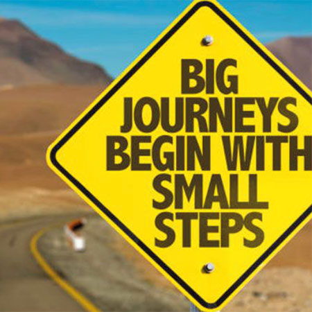 Sign post saying "Big Journeys Begin With Small Steps"